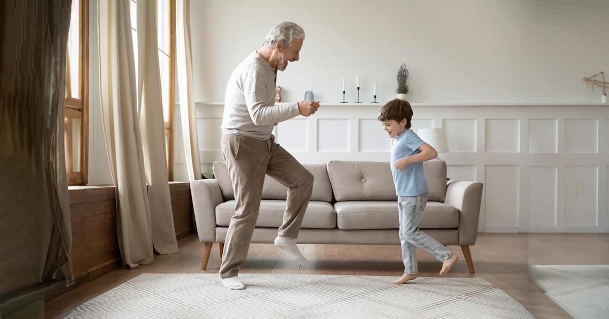 Grandfather dancing in the living room with his grandson